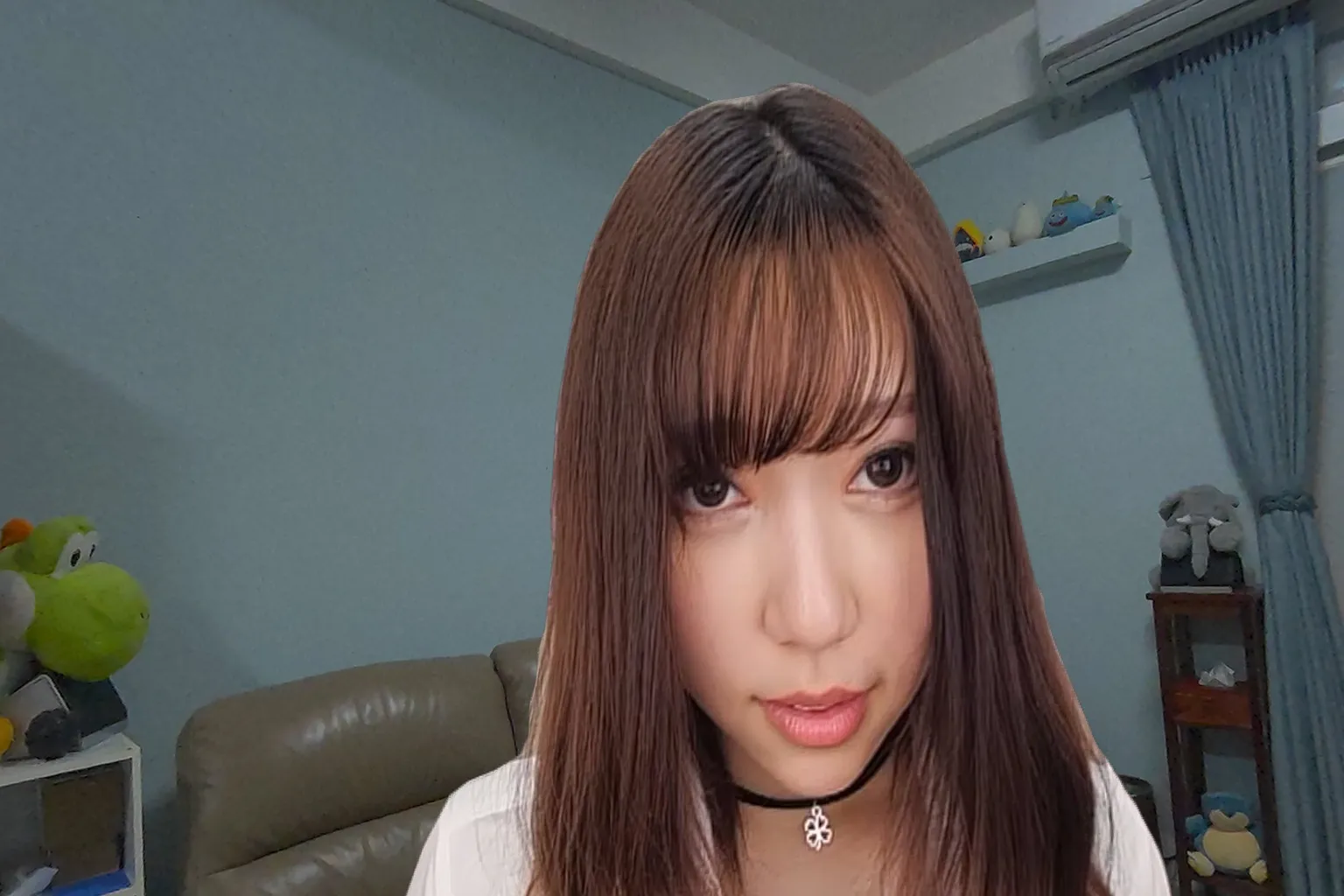 Long-haired woman wearing a black choker, looking straight into the camera with a calm yet intense expression that feels confident and composed.