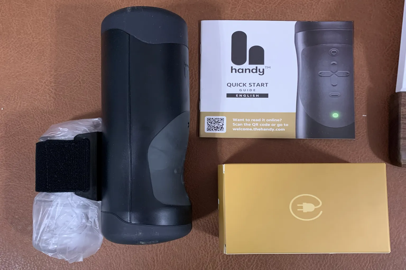 A neatly arranged layout of all included items, including The Handy unit, manual, and accessories.