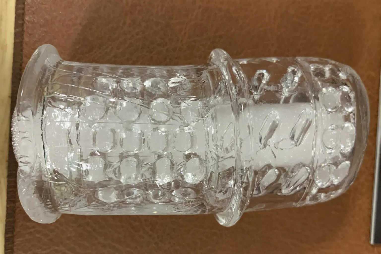 A close-up of The Handy official sleeve, showing the transparent material with its internal structure and detailed texture visible.