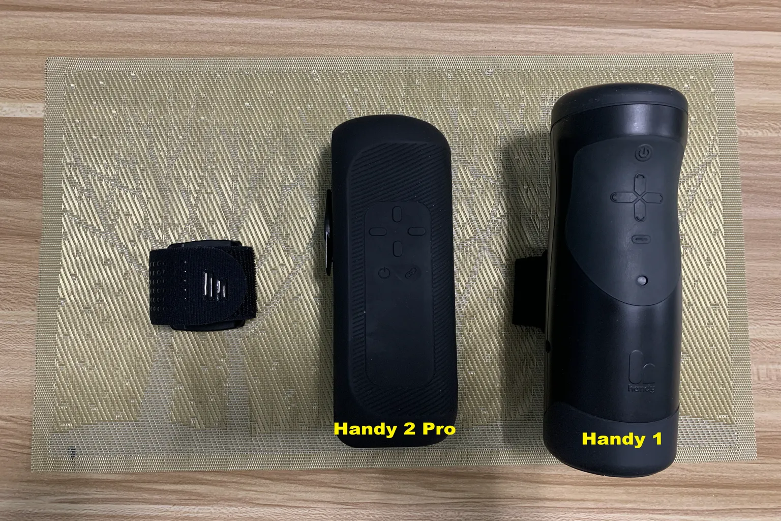 The Handy 1 與 The Handy 2 Pro 正面比較,展示兩代機身外型、按鍵配置與固定帶差異。